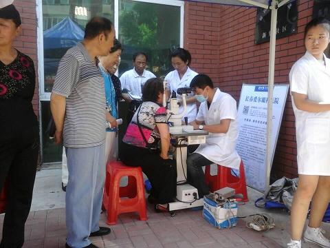 图为爱耳眼科医院的志愿者在为社区居民做检查.jpg
